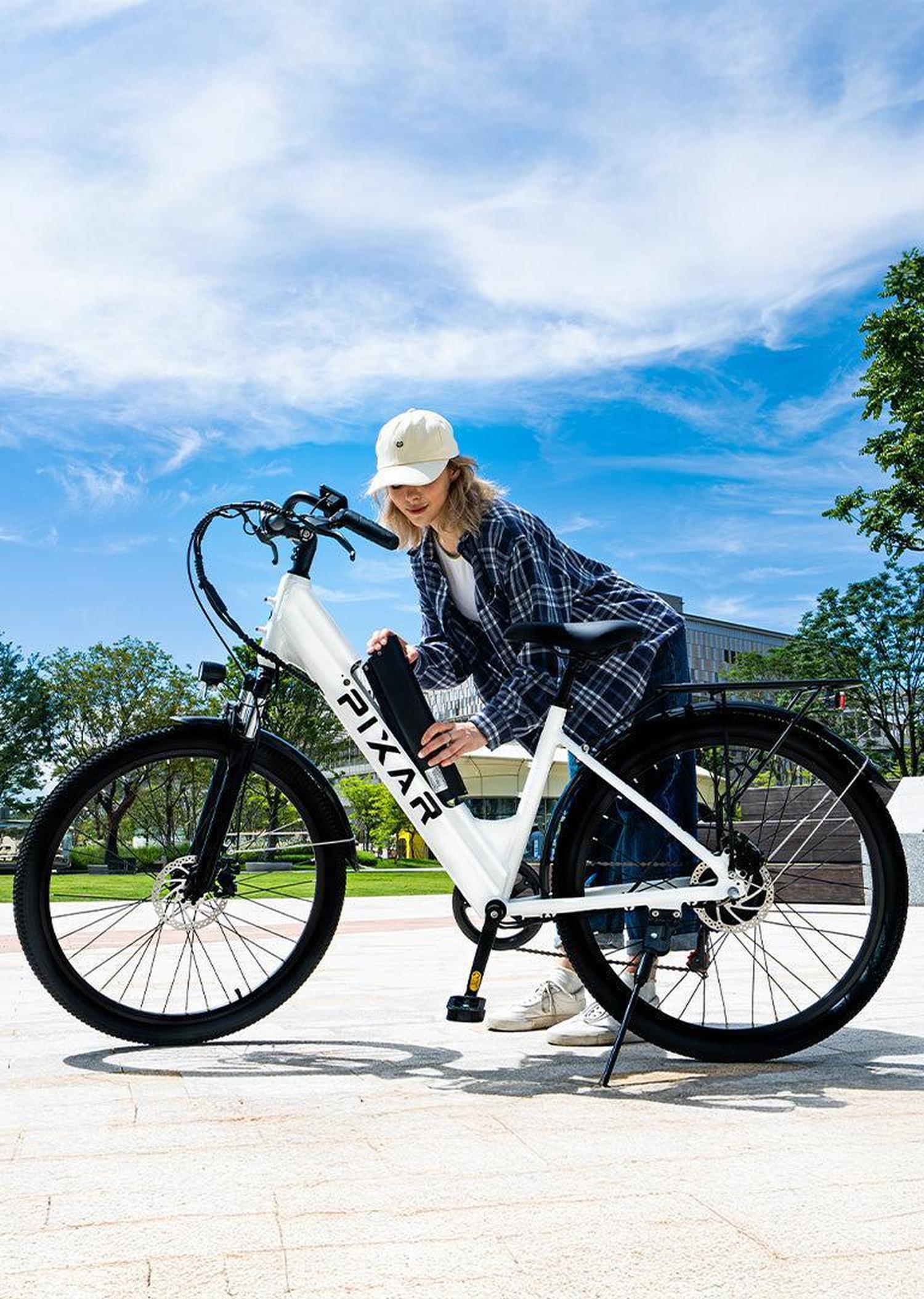 Person interacting with a white bicycle branded 'Pixar' on a sunny day.