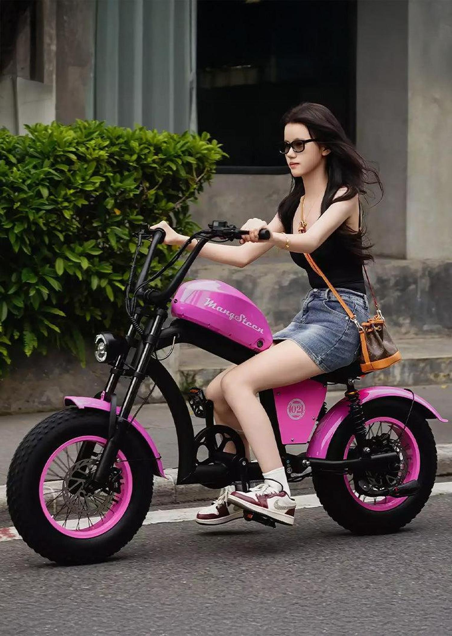 Woman riding a pink and black electric bike on a street.