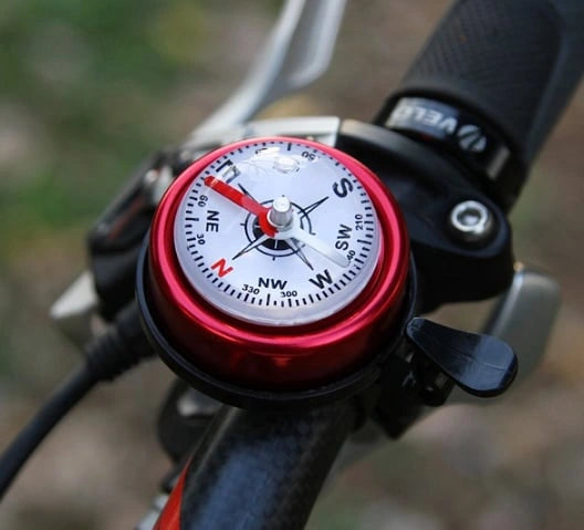 Red bicycle compass bell installed on a handlebar