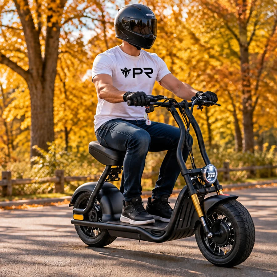 A helmeted rider wearing a white Punk Ride logo T-shirt uses the MotoTec Diablo 48V 1000W Lithium Electric Scooter in an autumn setting. Mobile collection banner.