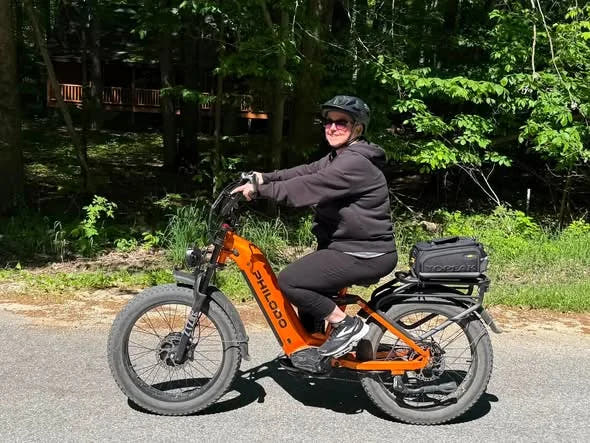 Rider on a PHILODO Falcon Step-Thru Orange bike with additional luggage not included