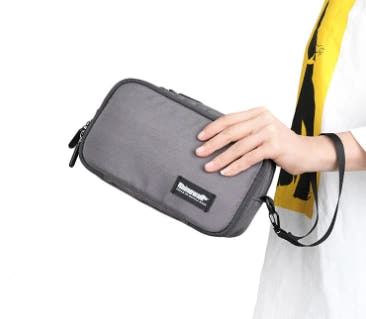 Grey bicycle shoulder and handlebar bag shown being held