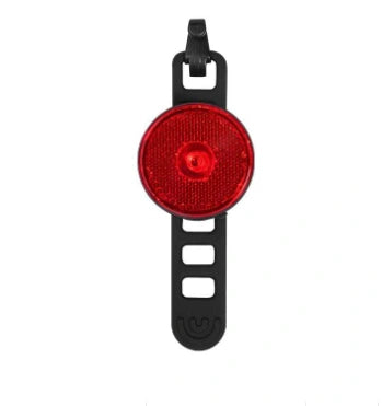 Red circular bicycle warning tail light and mounting strap on white background