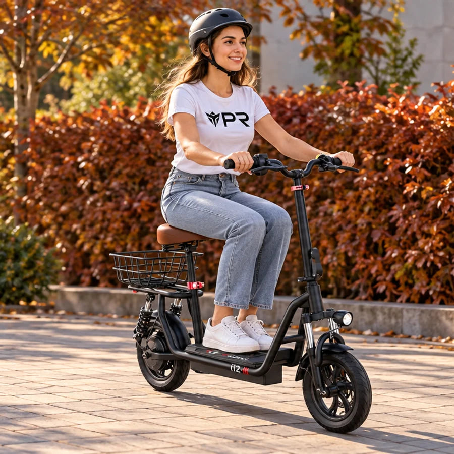 A helmeted rider wearing a white Punk Ride logo T-shirt rides the ISCOOTER i12 Electric Scooter in an autumn setting. Mobile collection banner.