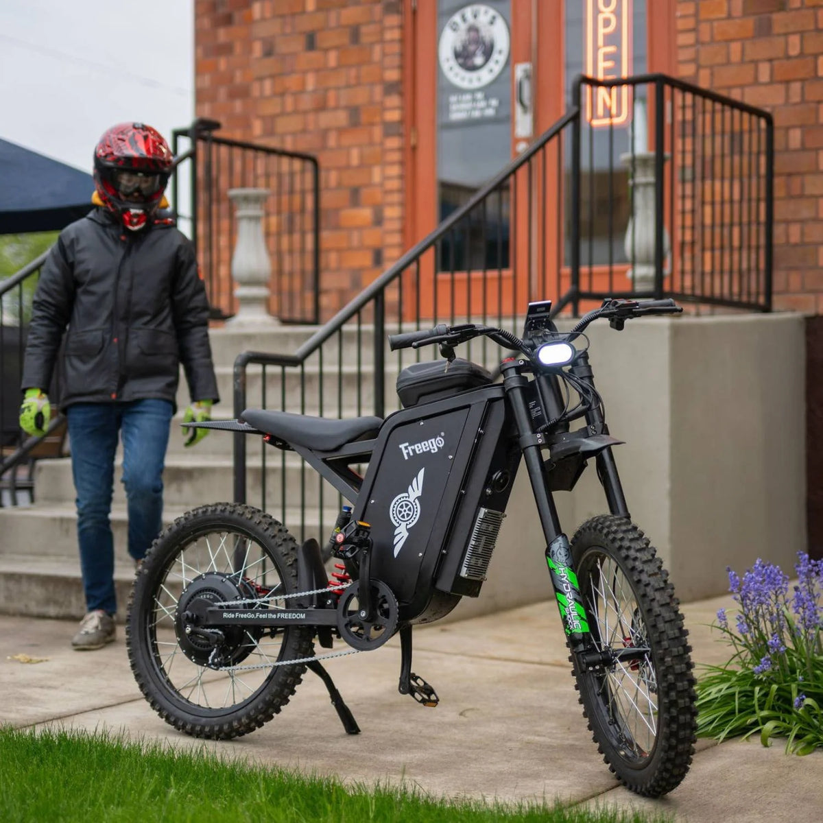 Rider beside a Freego X3 Pro electric dirt bike in an urban setting