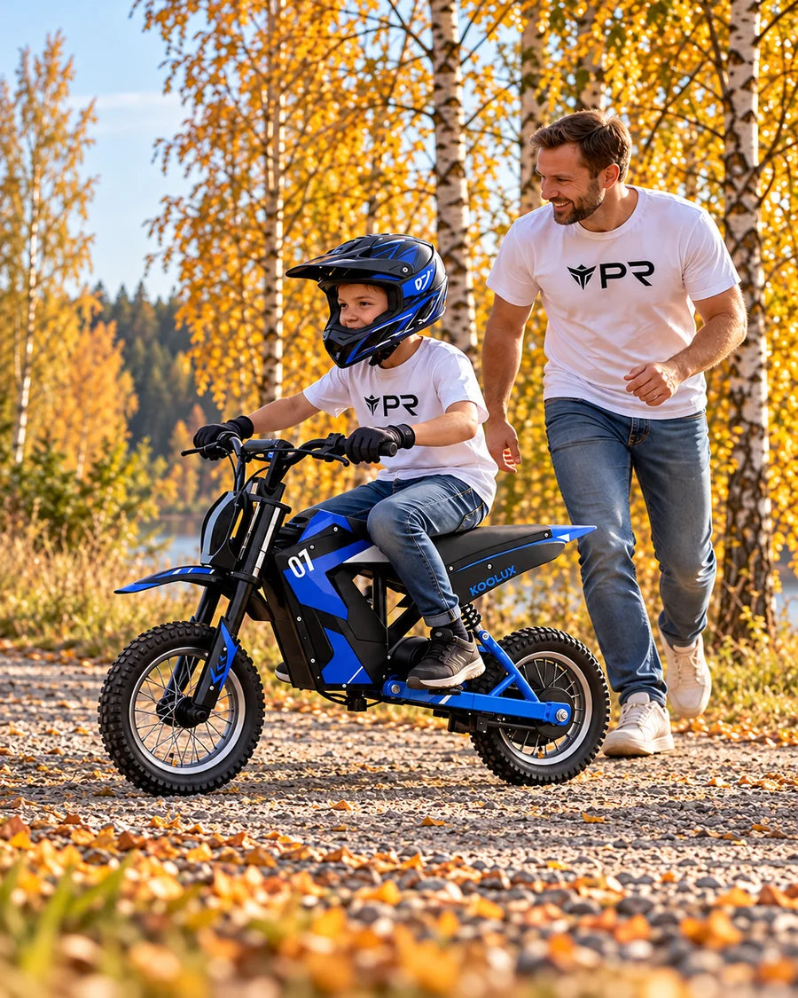 A helmeted child rides a blue KOOLUX EV12M kids electric bike beside an adult in white Punk Ride logo T-shirts on an autumn woodland path.