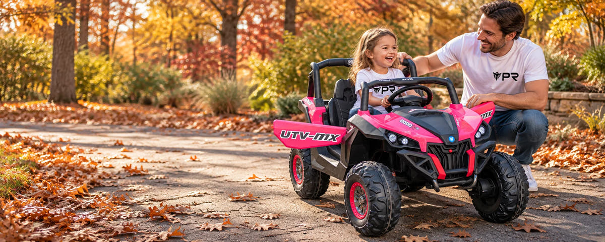 A child sits in a pink Mini Moto UTV ride-on toy beside an adult in white Punk Ride logo T-shirts on an autumn path.