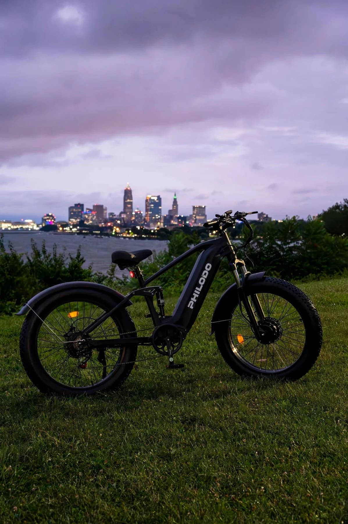 PHILODO Falcon Step-Thru Black electric bike near a city waterfront