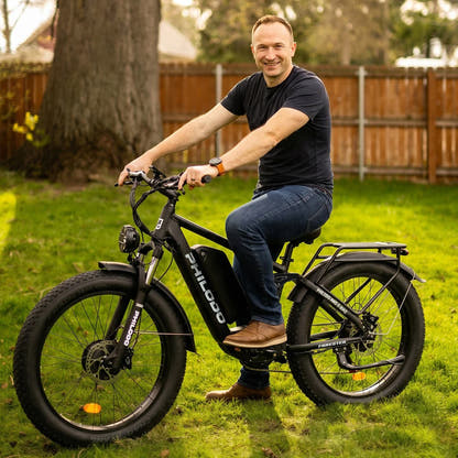 Rider seated on a PHILODO Forester Green electric bike in a garden