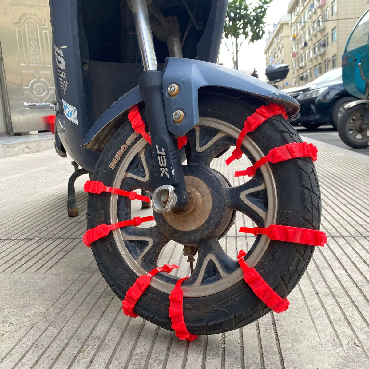 Red nylon tyre straps installed on a scooter tyre; fitting reference